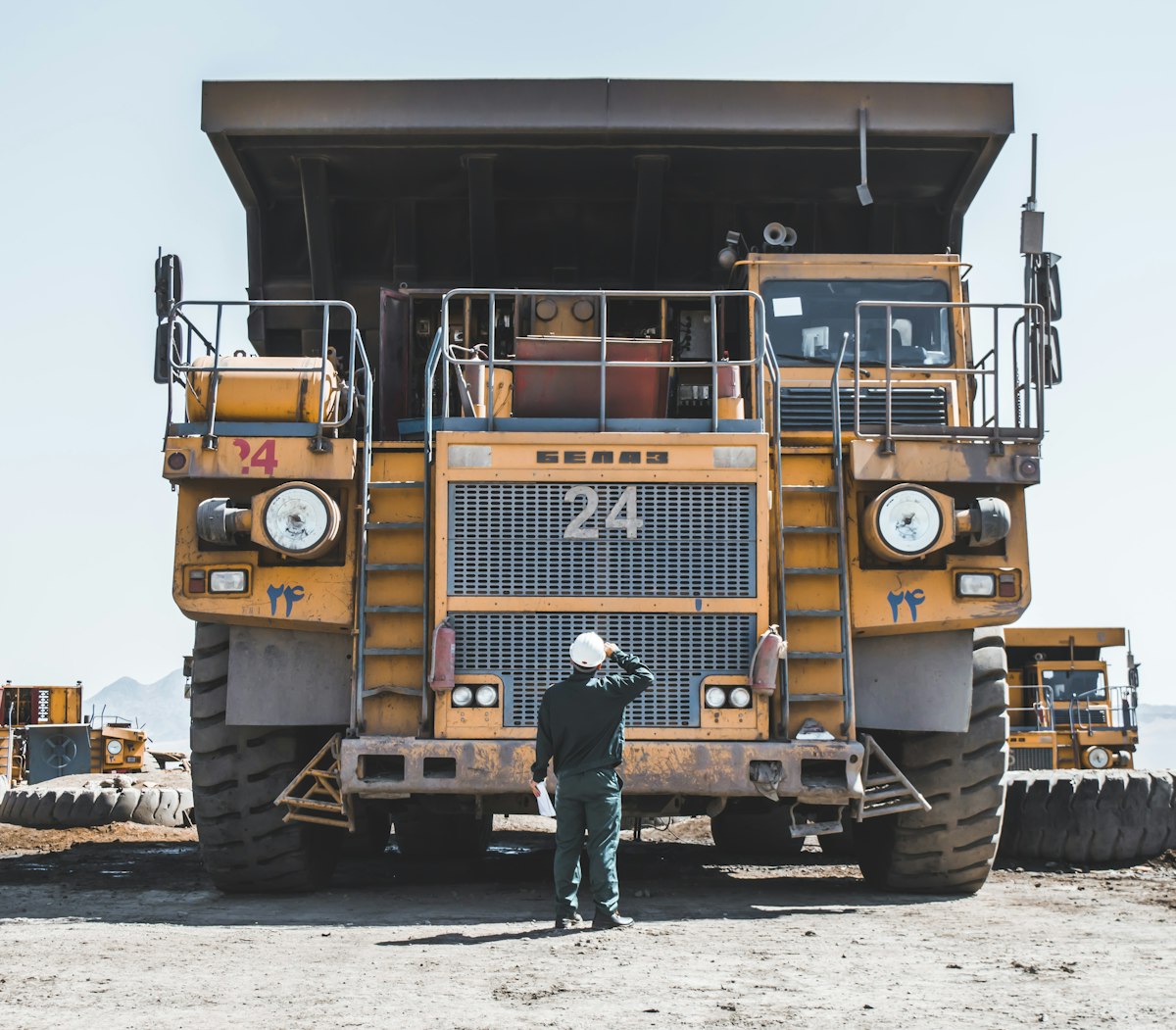 Trabajador realizando inspección de seguridad junto a camión minero en un yacimiento andino